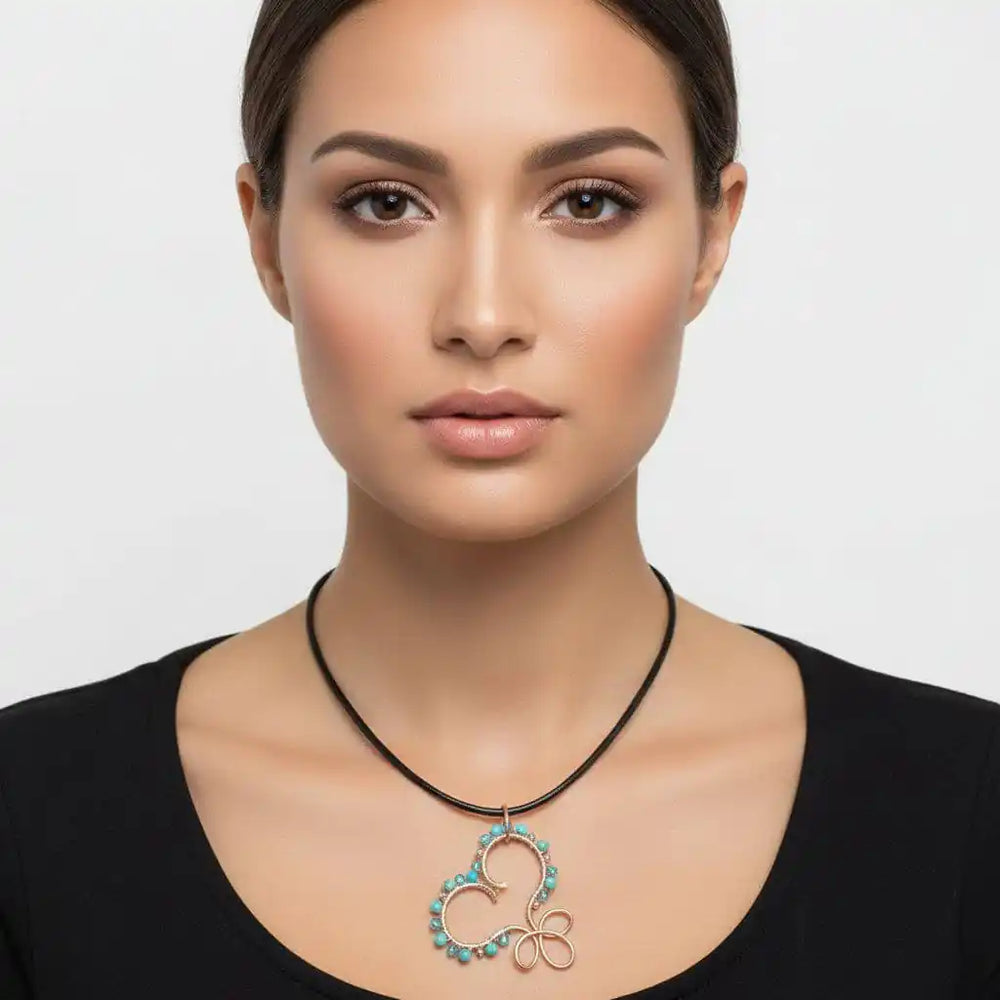Wire Wrapped Copper Turquoise Heart Infinity Charm Necklace displayed on a model featuring turquoise beads and a copper design.
