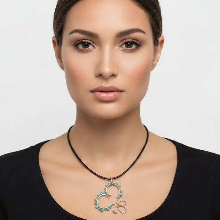 Wire Wrapped Copper Turquoise Heart Infinity Charm Necklace displayed on a model featuring turquoise beads and a copper design.