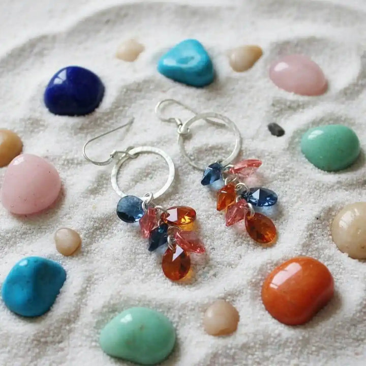 Silver Circle Multi Color Crystal Drop Dangle Earrings displayed on sandy surface with colorful stones.