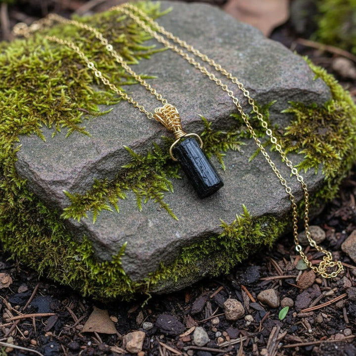 Wire Wrapped Raw Black Tourmaline Gemstone Necklace displayed on a moss-covered stone background.