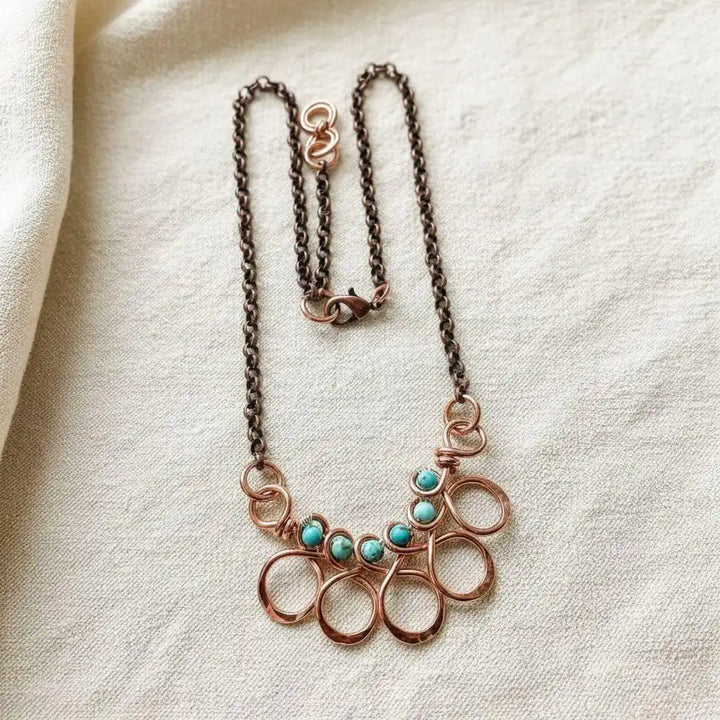 Seen on Ashley Liao Copper Turquoise Wire Wrapped Necklace featuring a unique wire design and turquoise accents.