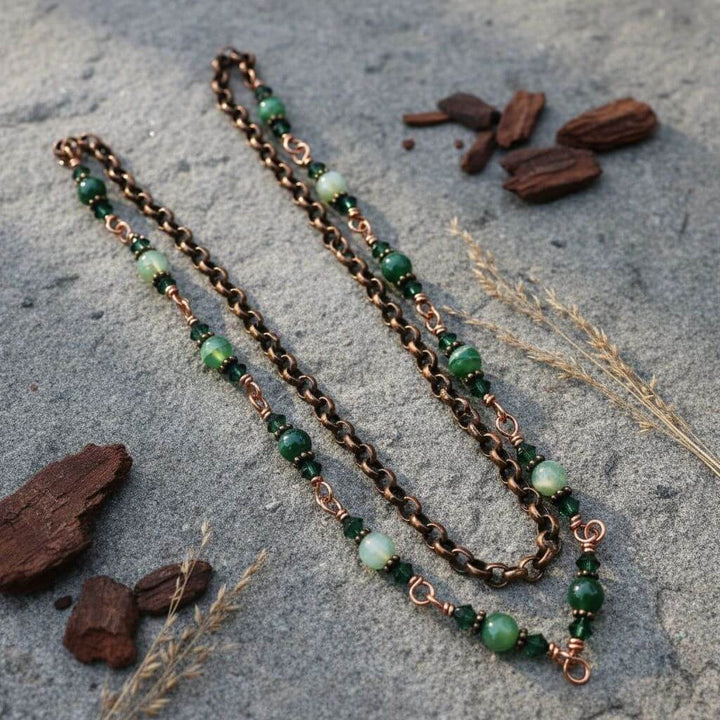 24 inches emerald agate wire wrapped necklace with green gemstones and copper accents on a stone background.