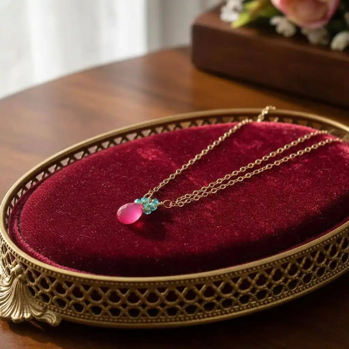 Gold Filled Pink and Aqua Gemstone Crystal Chain Necklace displayed on a red velvet surface, showcasing vibrant colors.