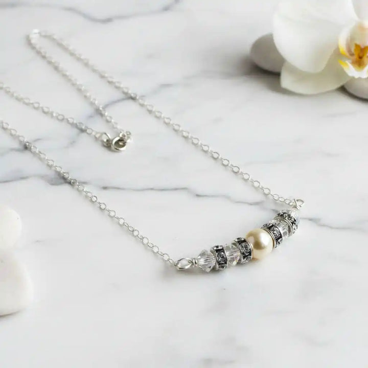 Silver Swarovski Crystal Pearl Bar Bridal Necklace featuring crystal pearls on a silver chain elegantly displayed on marble.