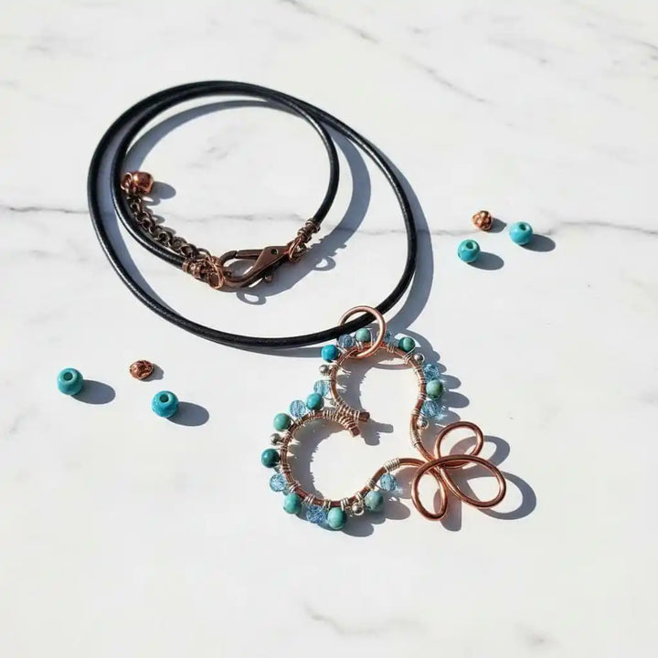 Wire Wrapped Copper Turquoise Heart Infinity Charm Necklace with turquoise beads on a black cord