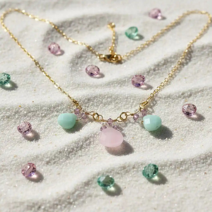 Gold Filled Light Pink and Mint Chalcedony Chain Necklace with briolette drops on sandy surface.