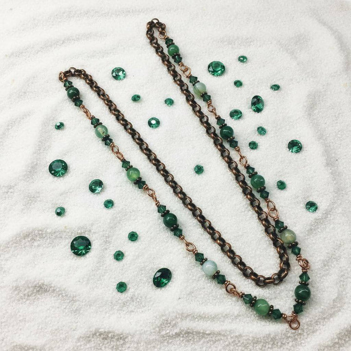 24 inches emerald agate wire wrapped necklace displayed with emerald gemstones on a soft surface.