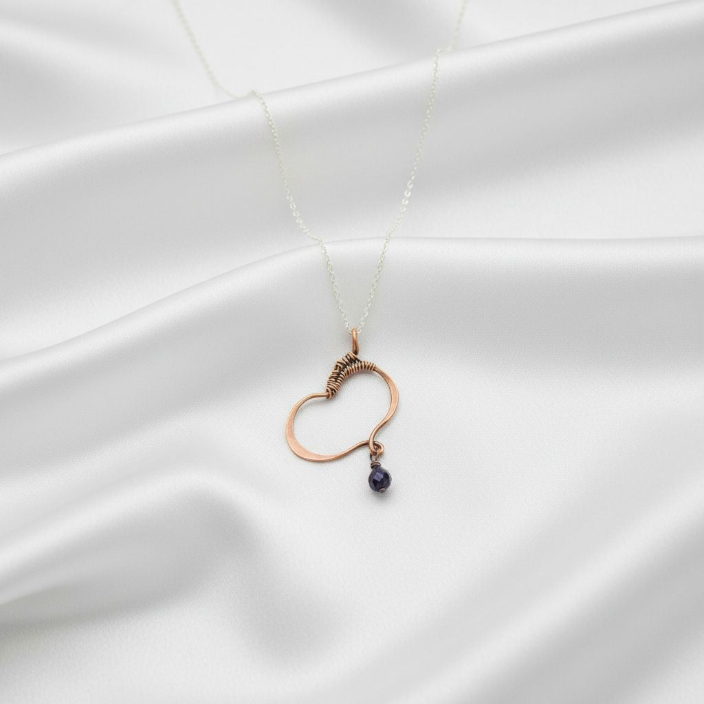 Hammered Copper Butterfly Wing Child Abuse Survivor Necklace with purple crystal pendant on a satin background.