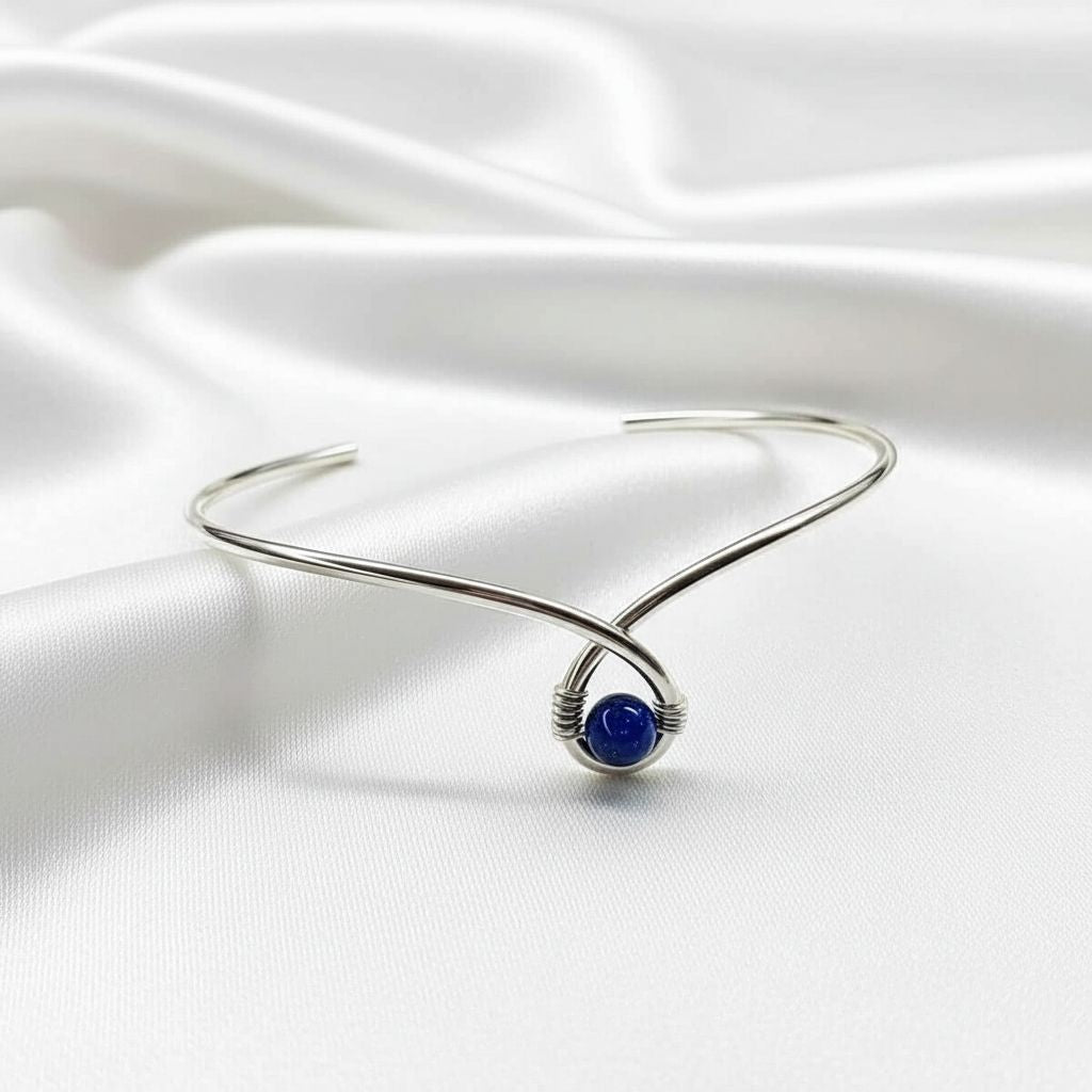 Silver Blue Bead Child Abuse Awareness Ribbon Bangle featuring a blue sandstone bead on a silver teardrop bangle.