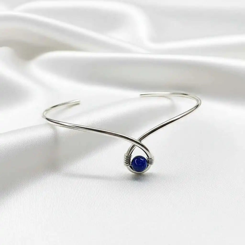 Silver Blue Bead Child Abuse Awareness Ribbon Bangle featuring a blue sandstone bead on a silver teardrop bangle.