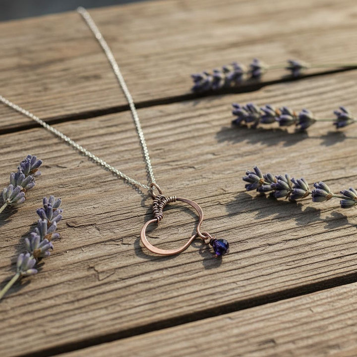 Hammered Copper Butterfly Wing Child Abuse Survivor Necklace with black Swarovski crystal teardrop on wooden background.
