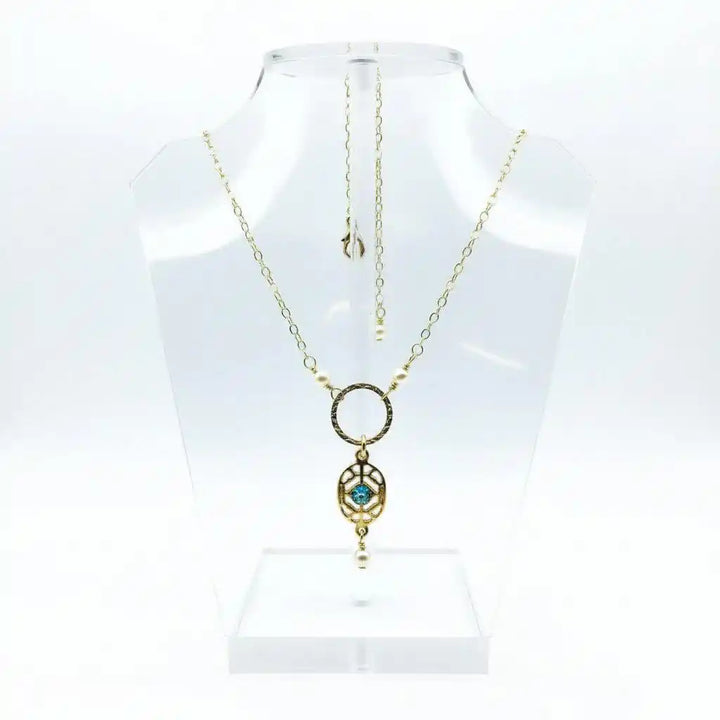 14 K Gold-Filled Hammered Open Circle Filigree Necklace displayed on a clear jewelry stand.