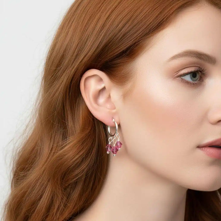 Mini Sterling Silver Hoop Pink Crystal Dangle Earrings worn by a woman with red hair, showcasing their sparkling design.