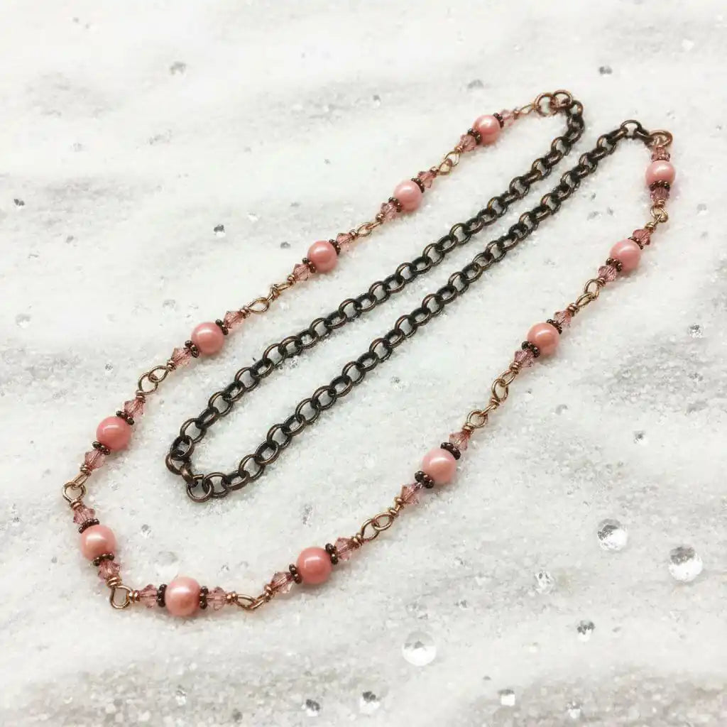 24-Inch Copper Peach Pearl Crystal Wire Wrapped Necklace featuring peach pearls and copper chain on a textured surface.