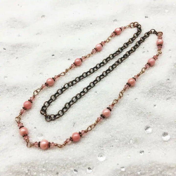 24-Inch Copper Peach Pearl Crystal Wire Wrapped Necklace featuring peach pearls and copper chain on a textured surface.