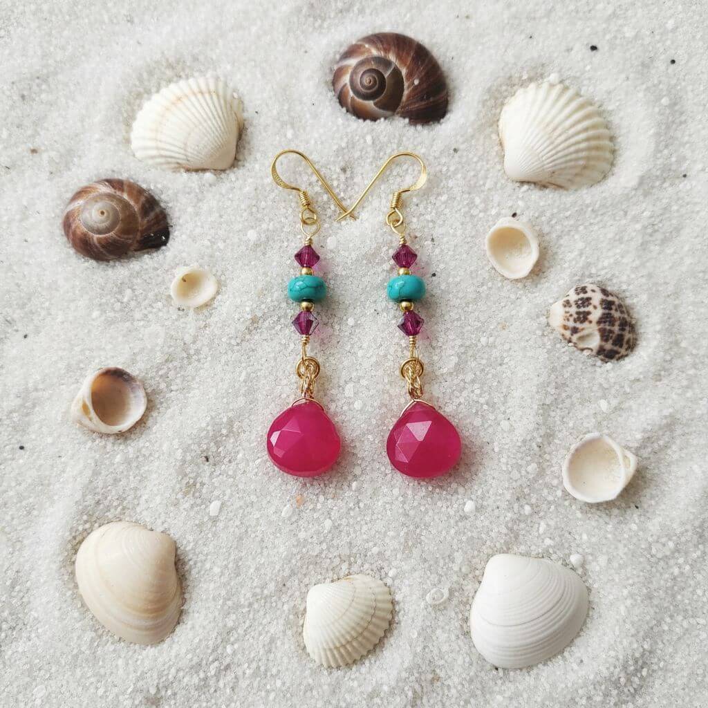 Gold Filled Wire Wrapped Pink Turquoise Gemstone Earrings with pink chalcedony and turquoise heishi beads on sandy background.