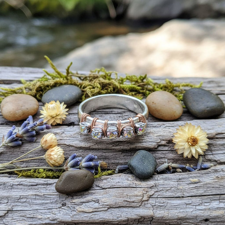 Rose Gold Filled Wire Wrapped Sparkly Crystal Bling Ring displayed on wooden surface with stones and flowers.