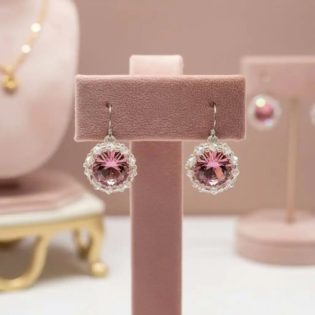 Handmade Beaded Bezel Pink Crystal Halo Earrings displayed on a pink earring stand with sparkling Swarovski crystals.