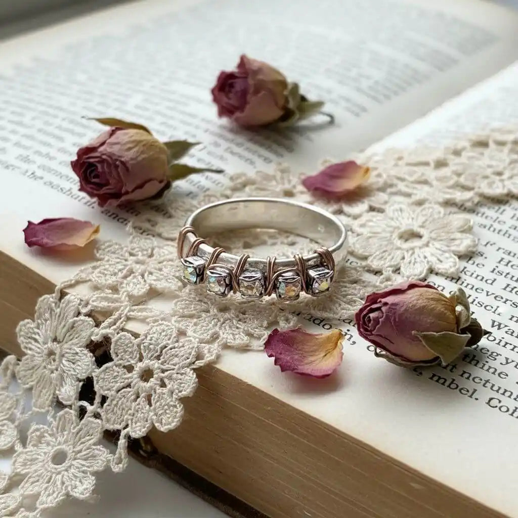 Rose Gold Filled Wire Wrapped Sparkly Crystal Bling Ring on lace with dried roses and an open book.
