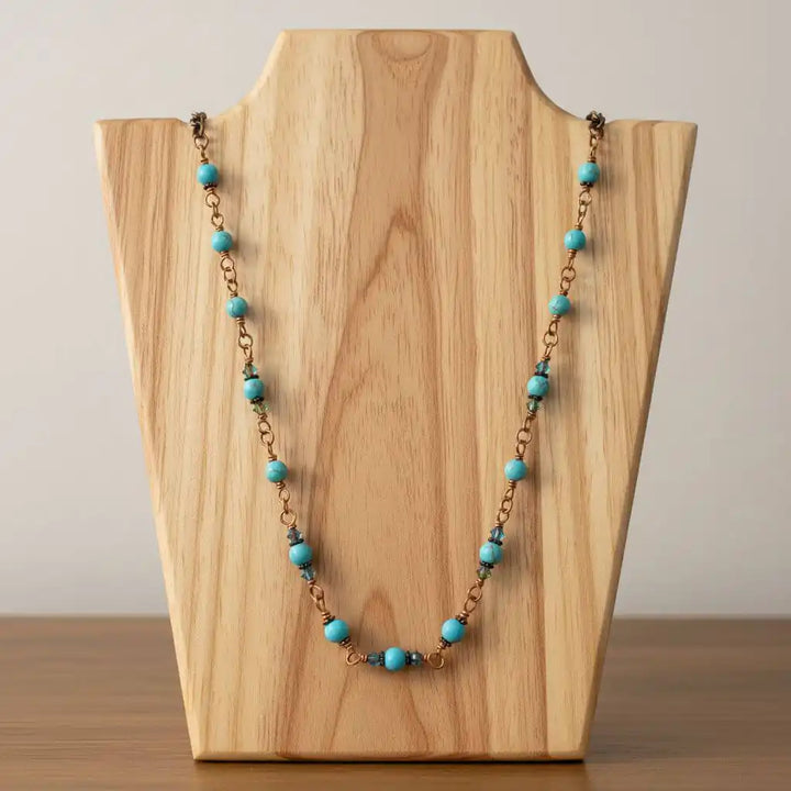 Wire Wrapped 24 Inches Copper Turquoise Necklace displayed on a wooden stand, featuring turquoise gemstones and antiqued copper.