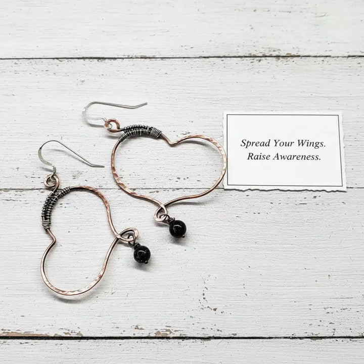 Sculpted Copper Butterfly Wing Abuse Survivor Earrings with black Swarovski crystal dangles on white background.